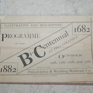 Puede incluir: Un programa impreso vintage titulado "Programa del Bi-Centenario en Filadelfia" de 1882. El programa es beige con texto negro y presenta las fechas del 24, 25, 26 y 27 de octubre. Emitido por la Philadelphia & Reading Railroad Co.
