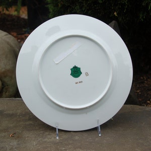 Peut inclure: Assiette en c&eacute;ramique blanche avec un logo vert et or au dos. Le logo repr&eacute;sente un bouclier avec une couronne et le texte "Made in Italy".