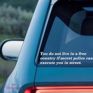 May include: A teal car window with the text: "You do not live in a free country if secret police can execute you in street." A side mirror is visible. The Pimnipap logo is in the lower left corner.