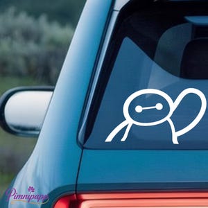 May include: A white vinyl decal featuring a minimalist line drawing of a round-headed character with two oval eyes connected by a horizontal line, applied to the rear window of a blue vehicle, positioned above the red taillight assembly.
