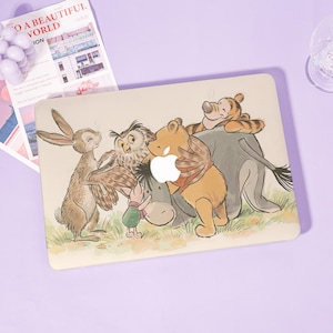May include: A beige laptop case featuring a colorful illustration of Winnie the Pooh and friends. The design includes characters like Pooh Bear, Tigger, Owl, and Piglet, with an Apple logo cutout.