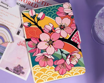 May include: A rectangular case with a floral design. The case features pink cherry blossoms on a branch against a backdrop of colourful stripes and patterns. The text "A BEAUTIFUL WORLD" is partially visible.