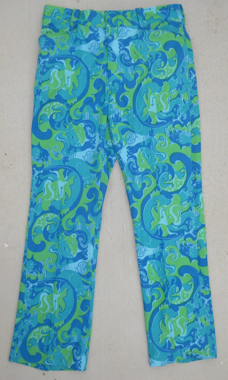 May include: A pair of vintage pants with a vibrant, swirling pattern in shades of blue and green. The pants have a straight leg cut and a high waist. The fabric appears to be a lightweight material, suitable for warmer weather.