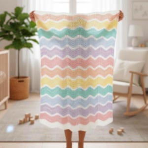 K&ouml;nnte beinhalten: Eine pastellfarbene Decke mit Zickzackmuster, die Wellen in Gelb, Gr&uuml;n, Blau, Lila und Rosa aufweist. Die Decke wird hochgehalten und zeigt ihr wellenf&ouml;rmiges Design und ihre weiche Textur. Die Decke besteht wahrscheinlich aus einem weichen Material, ideal f&uuml;r ein Kinder- oder Schlafzimmer.