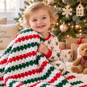 May include: A handmade crochet blanket featuring horizontal stripes in alternating colors of red, white, and dark green. The blanket has a textured, repeating stitch pattern throughout, creating a soft and cozy appearance with clean, straight edges.