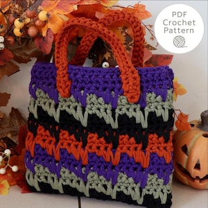 May include: A handmade crochet tote bag in a Halloween color scheme. The bag features a repeating pattern of black, orange, purple, and gray. The handles are orange. The text "PDF Crochet Pattern" is in a circle on the upper right.