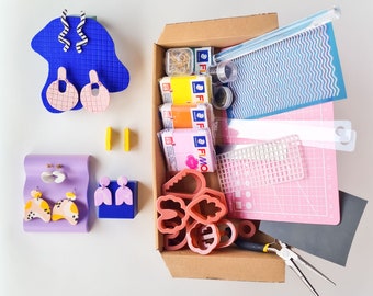 May include: A box filled with craft supplies for making earrings. The box contains colourful polymer clay, earring findings, and a variety of tools. The box is open and the contents are visible.