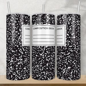Könnte beinhalten: Drei Edelstahlbecher mit einem Notizbuch-Design. Die Becher sind schwarz und weiß mit einem gesprenkelten Muster und einem weißen Etikett mit der Aufschrift "COMPOSITION BOOK". Jeder Becher hat einen silbernen Strohhalm.