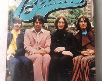 Libro vintage de los Beatles de 1975 con fotografías de John Paul, George Ringo y sobrecubierta de pulpo