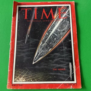 Könnte beinhalten: Eine Vintage-Ausgabe des Time-Magazins vom 30. Januar 1956 mit einer Titelillustration einer Rakete im Flug vor einem dunklen, sternenübersäten Hintergrund. Das Magazin hat einen roten Rand und den Titel "TIME" in großen roten Buchstaben. Der Text "THE MISSILE" ist ebenfalls sichtbar.