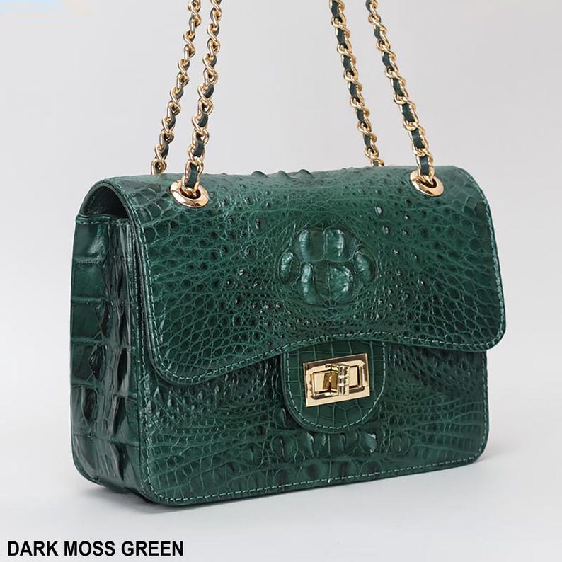 May include: Dark moss green handbag with a textured crocodile pattern. The bag features a gold chain strap and a gold clasp closure. The text "DARK MOSS GREEN" is at the bottom of the image.