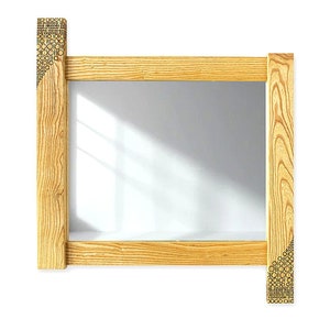 May include: A rectangular wooden mirror with a natural wood finish. The frame has a decorative pattern on the corners.