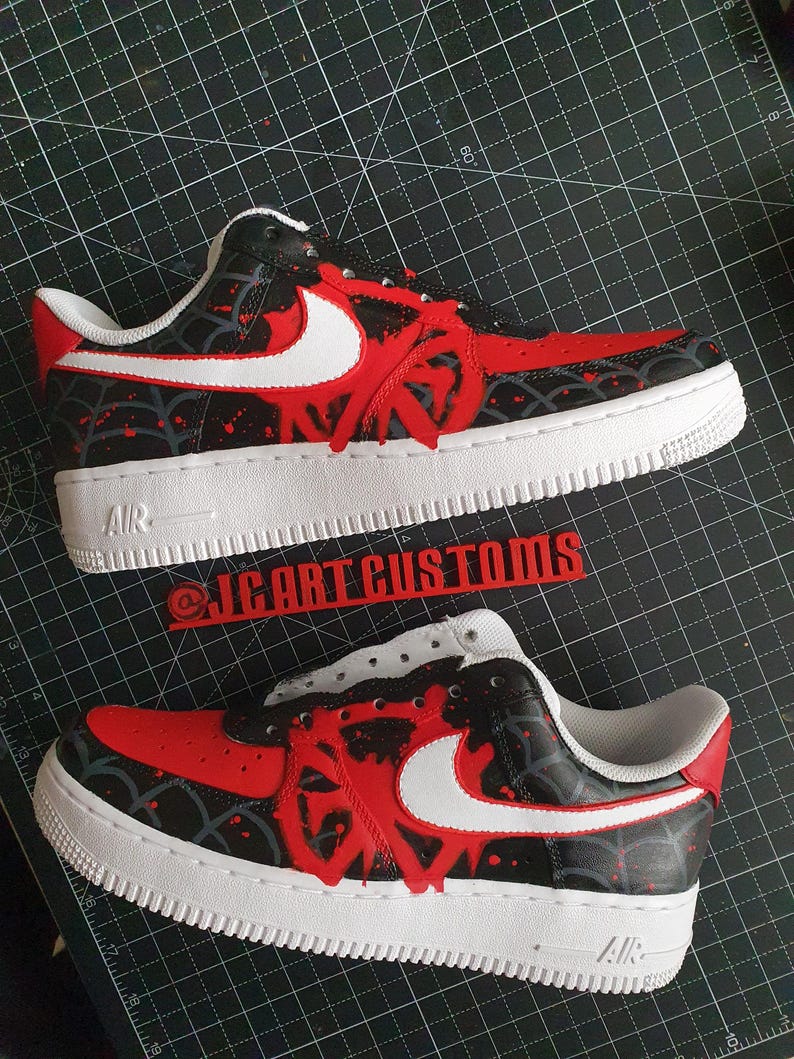Puede incluir: Zapatillas rojas y negras personalizadas con detalles blancos. Las zapatillas presentan una suela blanca, un dise&ntilde;o rojo en la puntera y los laterales, y un logotipo de Nike blanco. El texto "AIR" es visible en la suela.