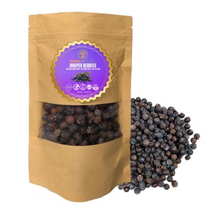 Puede incluir: Una bolsa de papel marrón con una ventana transparente llena de bayas de enebro oscuras. Una etiqueta morada y dorada dice "Cure and Pure Juniper Berries". Un montón de bayas de enebro sueltas se encuentra junto a la bolsa.