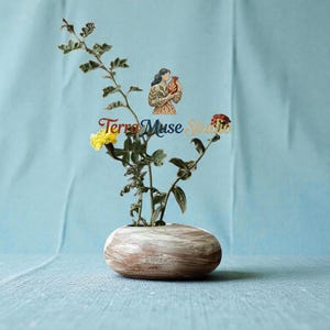Könnte beinhalten: Eine kleine, ovale Holzvase mit weißem und braunem Marmormuster. Die Vase enthält einen Zweig mit gelber und roter Blüte. Der Text "Terra Muse Studio" ist sichtbar.