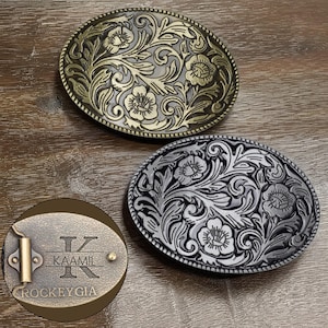 May include: Two oval belt buckles with floral patterns. One is bronze, the other silver. A smaller, oval buckle with the name "KAAMIL" and the text "ROCKEYGIA" is also visible.