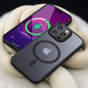 Puede incluir: Un teléfono inteligente con marco negro y panel trasero transparente que presenta un anillo de carga magnético circular y un logotipo de Apple. La pantalla muestra un fondo morado con un icono de carga de rayo verde y el texto "目前电量75%".