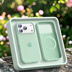 Può includere: Una custodia per telefono in silicone verde menta chiaro per iPhone, dotata di un ritaglio per tripla fotocamera, un logo Apple centrale e una fodera interna abbinata con un anello magnetico MagSafe circolare, in un vassoio quadrato.