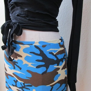 May include: A black wrap top with long sleeves and a blue, brown, and beige camouflage print skirt.