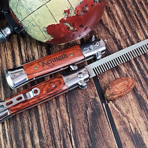 May include: A personalised pocket knife with a wooden handle and a comb. The knife has the name "Kenneth" engraved on the handle.