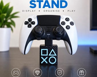 May include: A black controller stand featuring the PlayStation symbols square, triangle, cross, and circle in light blue on the front face. The stand supports a white and black wireless game controller. Text on the image reads CONTROLLER STAND.