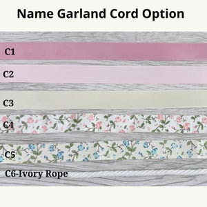 May include: A display of six name garland cord options labeled C1 through C6. The options include solid pink, light pink, and cream ribbons, two floral patterned ribbons with pink or blue flowers, and a twisted ivory rope labeled C6-Ivory Rope.