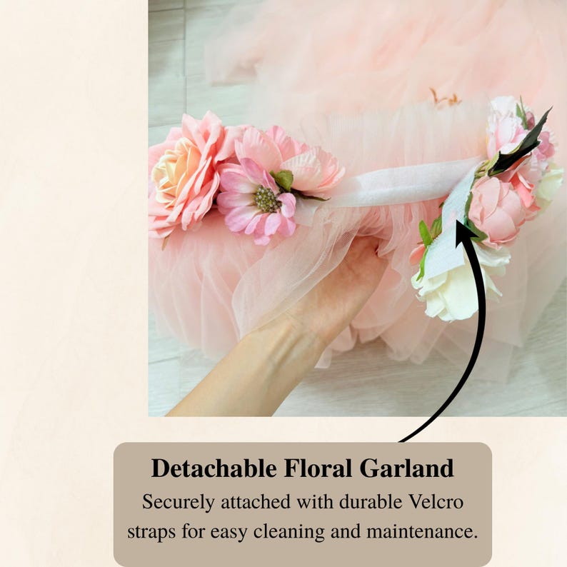 Puede incluir: Una prenda de tul rosa claro con una guirnalda floral desmontable. La guirnalda consta de flores artificiales rosas y blancas unidas a una tira de tela blanca con velcro. El texto en la imagen dice Detachable Floral Garland.