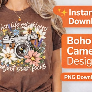 May include: Brown t-shirt with a vintage camera graphic surrounded by flowers. The text on the shirt reads "When life gets blurry adjust your focus." Orange rectangles with white text say "Instant Download", "Boho Camera Design", and "PNG Download".