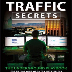 May include: Image of a person sitting at a desk with three computer monitors. The monitors display graphs and data. The book cover reads "TRAFFIC SECRETS" and "THE UNDERGROUND PLAYBOOK FOR FILLING YOUR WEBSITES AND FUNNELS WITH YOUR DREAM CUSTOMERS."