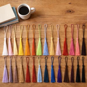 Puede incluir: Una colecci&oacute;n de treinta y dos borlas decorativas en un amplio espectro de colores, incluyendo blanco, rosa, amarillo, naranja, verde, azul, rojo, morado, marr&oacute;n y negro. Cada borla cuenta con un lazo a juego en la parte superior para colgar.