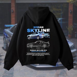 May include: Black hooded sweatshirt with a white graphic print of a blue Nissan Skyline R34 car. The text "NISSAN SKYLINE" and "NISSAN SKYLINE R34 INNOVATION THAT EXCITES" is printed below the car graphic.