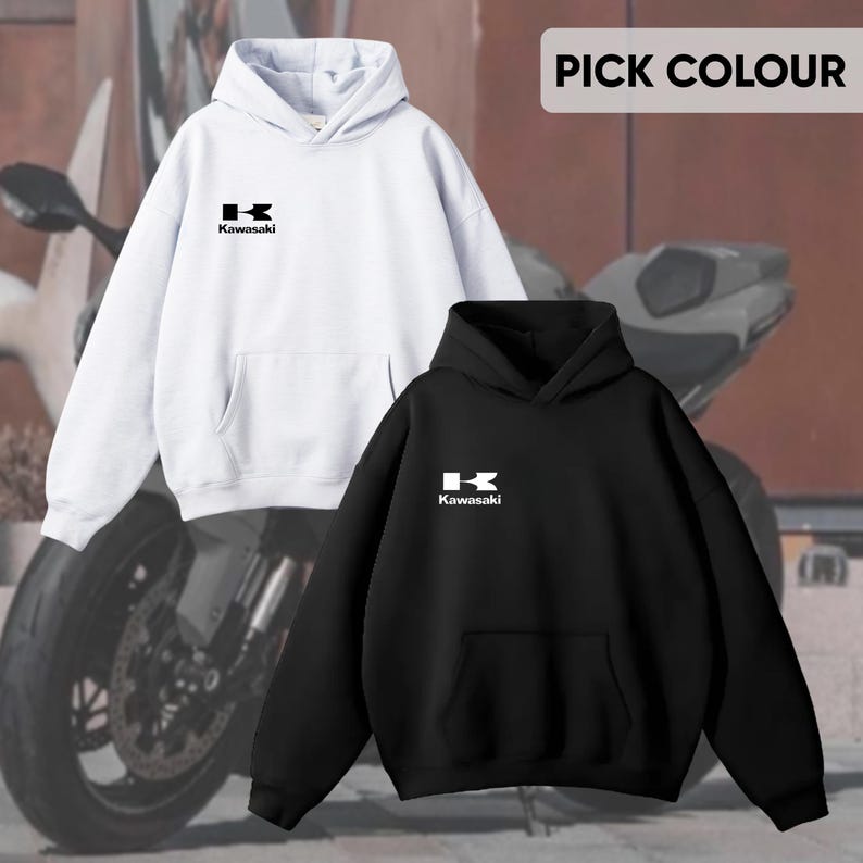 May include: Two hoodies, one white and one black, are displayed. Each features a front pocket and a hood. The Kawasaki logo is printed in white on the chest of each hoodie. The text "PICK COLOUR" is visible in the top right corner.