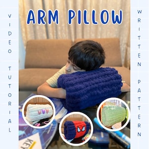 Op de afbeelding: Een marineblauw armkussen met de tekst "ARM PILLOW" in een blauw lettertype. De afbeelding toont een kind dat zijn arm op het kussen laat rusten. Extra afbeeldingen tonen het kussen in verschillende kleuren en ontwerpen. De woorden "VIDEO TUTORIAL" en "WRITTEN PATTERN" zijn ook zichtbaar.