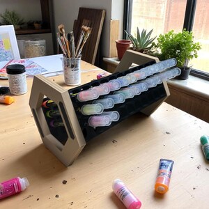 "Acrylic marker organizer with dual-angle stand on workshop desk"