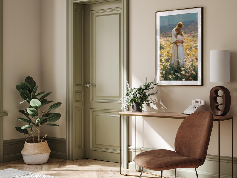 May include: Interior scene with a framed artwork depicting two figures embracing in a field of flowers. A brown chair, a table with a lamp and a telephone, and a potted plant are also visible. The walls are painted in neutral tones.