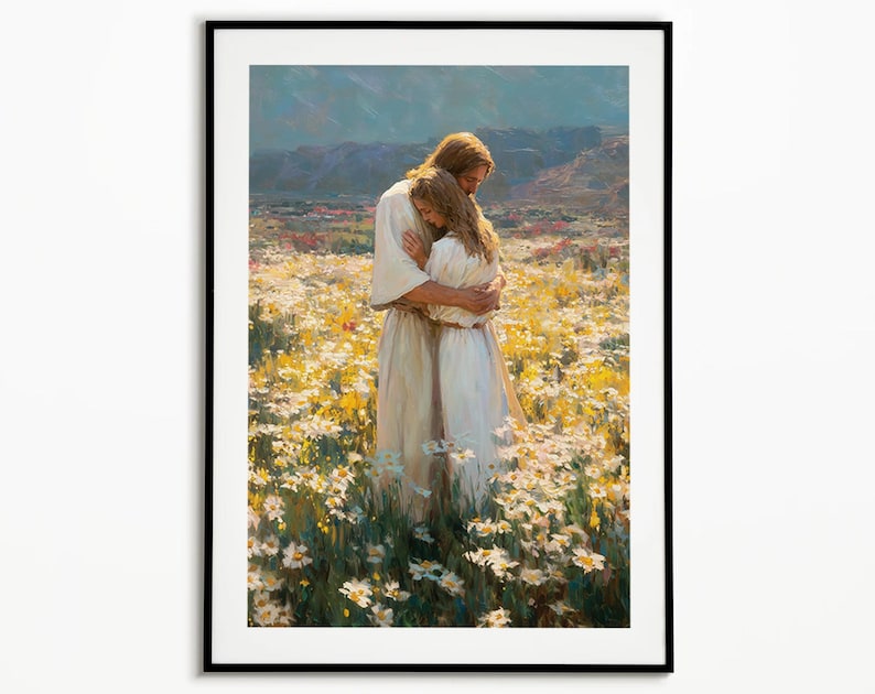May include: Framed art print depicting two figures embracing in a field of white and yellow flowers. The figures are dressed in white robes, with one figure having long brown hair. The background features rolling hills and a blue sky.