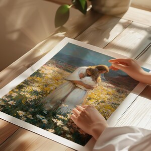 May include: A print of a painting depicting two figures embracing in a field of yellow and white flowers. The figures are dressed in white robes. The print is on a white background and is resting on a wooden surface.