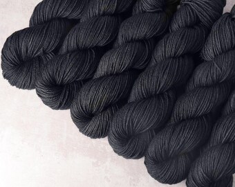 May include: Close-up of several skeins of dark charcoal grey yarn.
