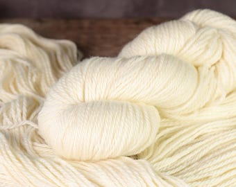 May include: A skein of soft, white yarn, perfect for knitting or crocheting. The yarn is made of natural fibers and has a smooth, even texture.