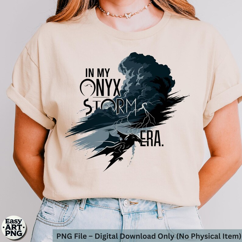 May include: A beige t-shirt with a graphic design featuring a black dragon, a storm cloud, and the text "In My Onyx Storm Era."