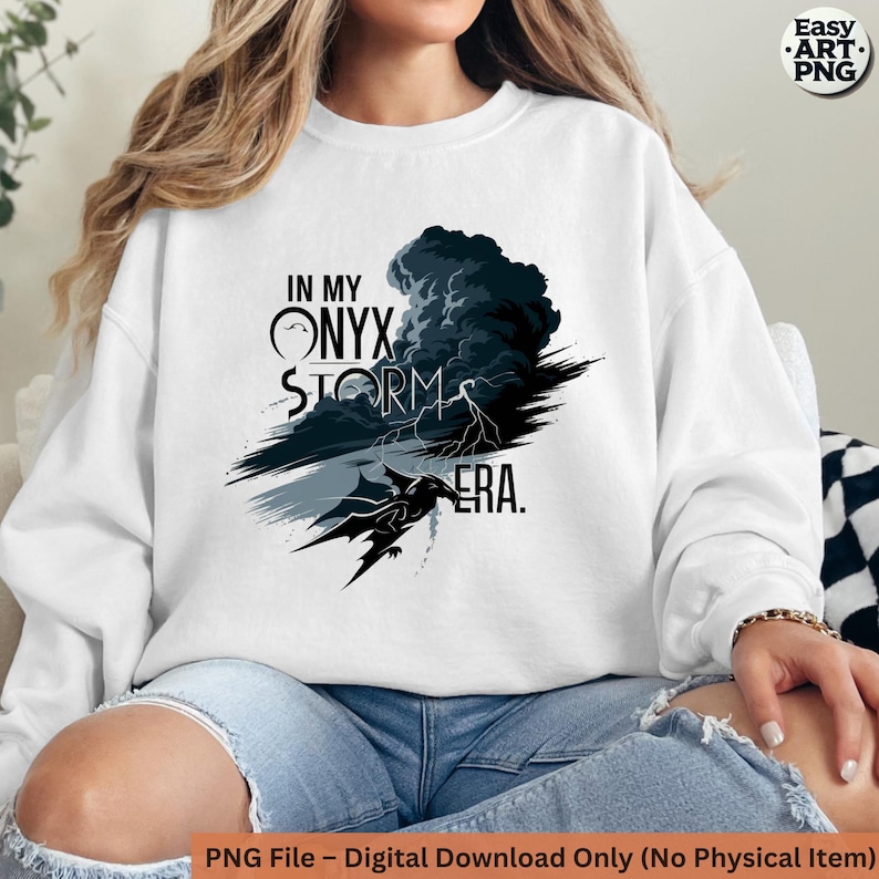 May include: White sweatshirt with a black and gray graphic design featuring a dragon, a storm cloud, and the text "In My Onyx Storm Era."