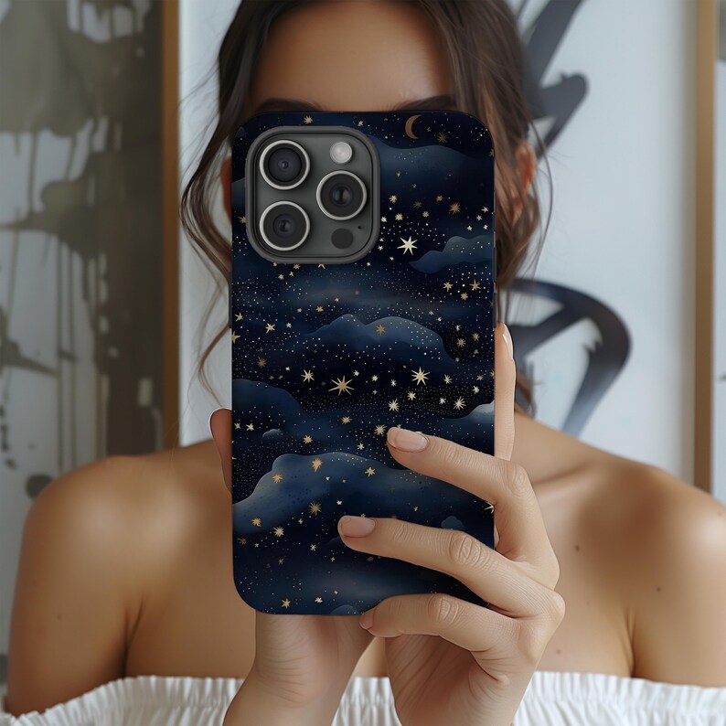 Pode incluir: Capa de smartphone com um design de c&eacute;u noturno azul escuro com estrelas douradas, nuvens e uma lua crescente. A capa tem um acabamento brilhante e um recorte para a c&acirc;mera.