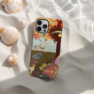Pode incluir: Capa de telefone colorida com um design de colagem com abelhas, flores e formas abstratas. A capa está colocada em uma superfície arenosa com conchas, criando uma estética de praia.