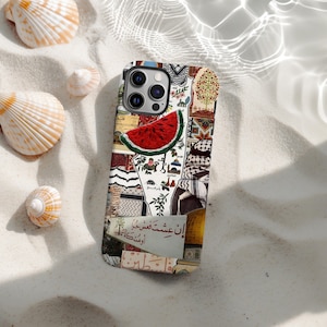 Puede incluir: Una funda de teléfono con un diseño de collage que presenta una rodaja de sandía roja, texto árabe y varios patrones. La funda está rodeada de conchas marinas sobre una superficie arenosa, creando una estética veraniega.