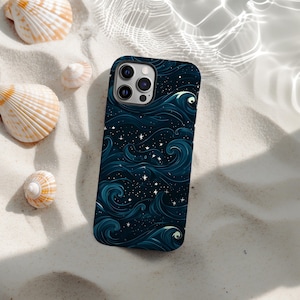 May include: A smartphone case with a dark blue ocean wave design and white stars. The case is lying on white sand with seashells scattered around it. The case has a glossy finish.