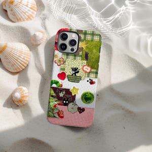 Op de afbeelding: Een kleurrijke telefoonhoes met een patchwork-ontwerp. De hoes heeft een groen-wit geruit gedeelte, een rood-wit geruit gedeelte en verschillende patches met illustraties van een zwarte kat, harten en sterren. De tekst op de hoes luidt "Happiness comes in waves, you'll find it again."