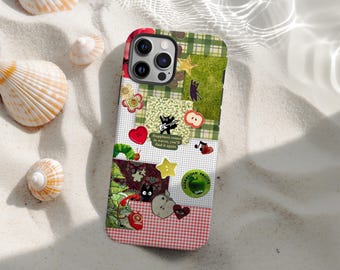 May include: A colorful phone case with a patchwork design featuring various patterns and illustrations. The case includes a green and white plaid section, a red and white checkered section, and several patches with images of a black cat, hearts, and stars. Text on the case reads "Happiness comes in waves, you'll find it again."