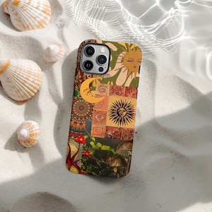 May include: A colorful phone case with a patchwork design featuring sun, moon, and mushroom illustrations. The case has a mix of warm colors like orange, brown, and green, with a textured appearance. The case is lying on a sandy surface with seashells.