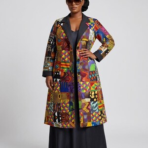 May include: A long-sleeved coat featuring a vibrant patchwork design of various colourful geometric and abstract patterns. The coat has a solid dark grey lapel and cuffs, a button-down front closure, and a knee-length hemline worn over a black dress.