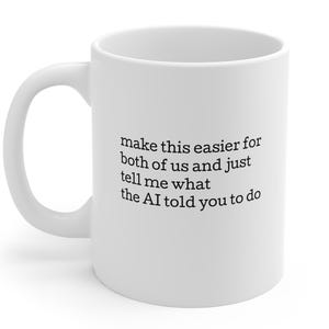 Può includere: Tazza da caffè in ceramica bianca con manico curvo. La tazza presenta un testo nero che recita: "make this easier for both of us and just tell me what the AI told you to do."